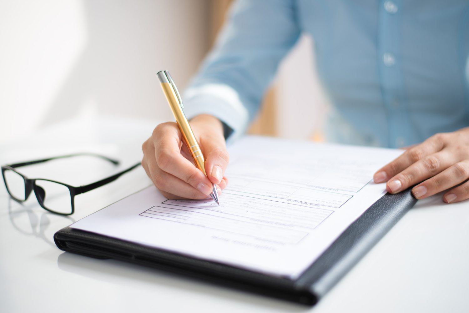 Closeup of business woman making notes in document<br />
